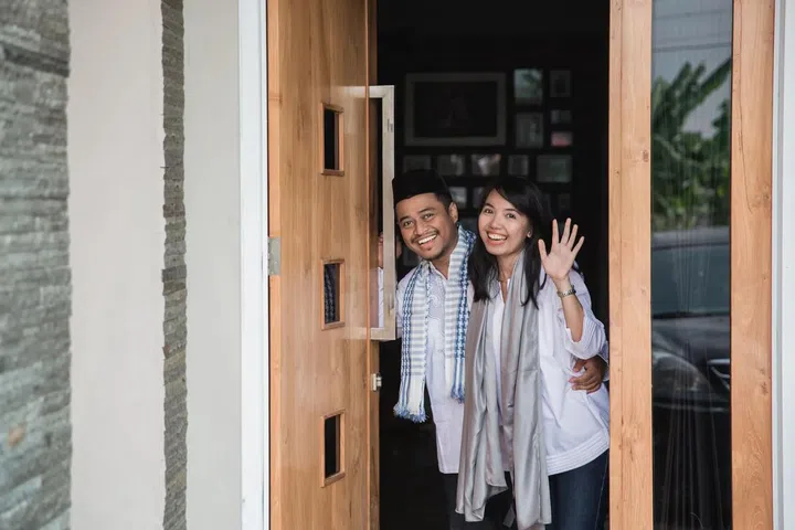 Happy asian girl and boy standing in front of the door. Photo 123RF