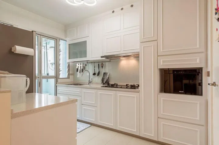 The homeowners chose a cream white palette and wainscotted panelling for a refined look. Interior design by Space Define Interior.