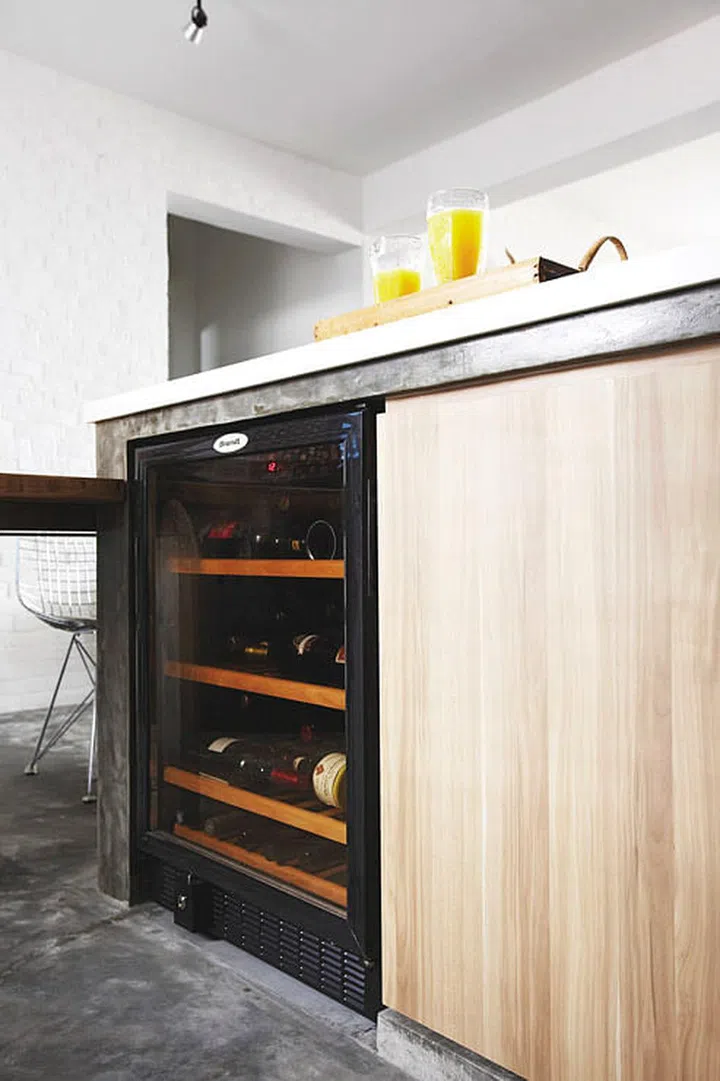The wine fridge is tucked neatly under the kitchen top. 