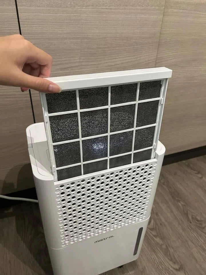 Hand pulling out the filter in the Mistral 10L Dehumidifier with Ionizer and UV, MDH1022, priced at $399.