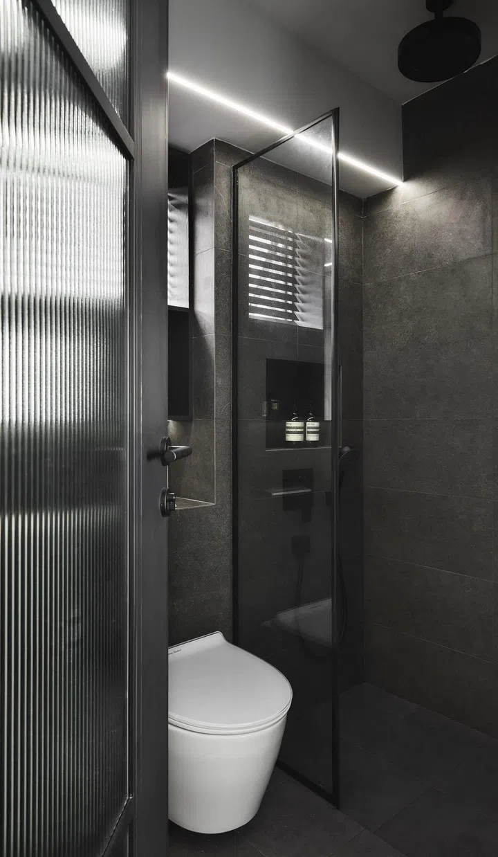 A white WC in an all-black bathroom in this 4-room HDB in Punggol.