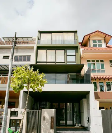 The rebuilt four-storey home asserts itself along the street with a boxy, glass-fronted form—a move its homeowners describe as “biting the bullet” after neighbouring houses began rebuilding.