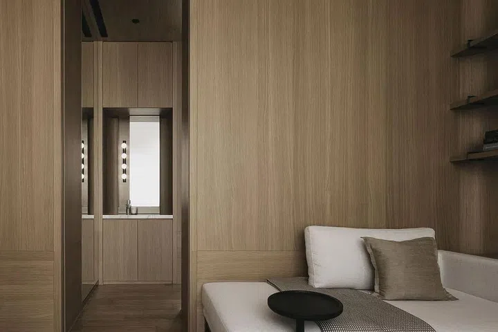 In the master bedroom, oak natural veneer is used to clad the walls, including the one that separates the bedroom from the cabin-like walk-in wardrobe of this 8 Napier Road condominium. (Photo: Studio Periphery)