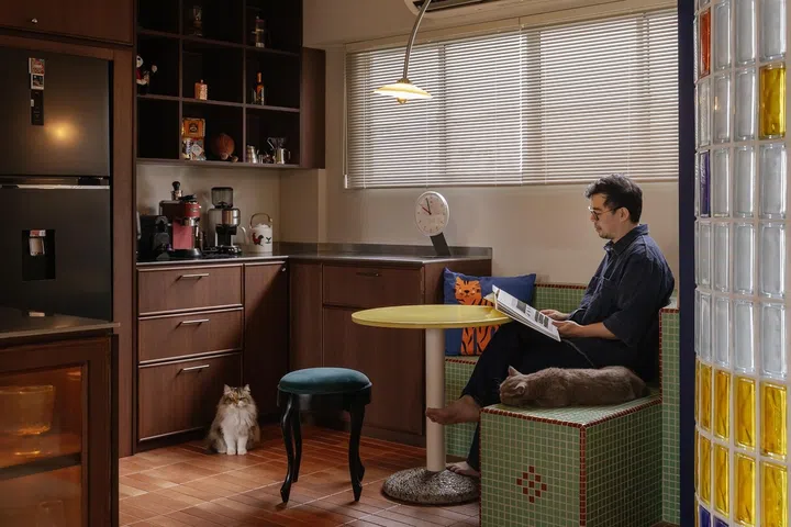 Homeowner, L, poses for a photo in the coffee corner with his cat.