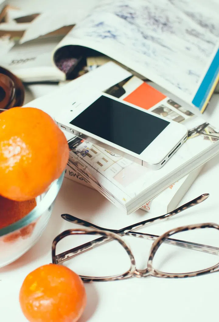 Business objects, books, magazines, smartphone, glasses and a cup of coffee on office table. Photo 123RF