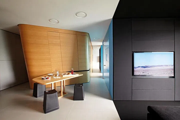 The dining table can be slid out from the centrepiece. Black "computer key" stools complement the wooden table and lend a quirky finish. Cake display glassware from Egg3; dip bowls and decanter from Molecule. (Home reno: $140K)