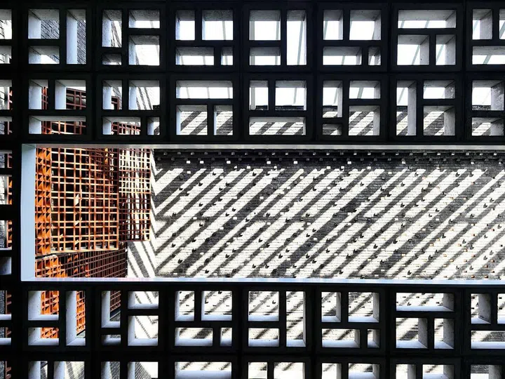 A deft use of textured bricks modulated with openings coupled with a striking pre-cast concrete screen helps to shield views of the house while providing visual interest.