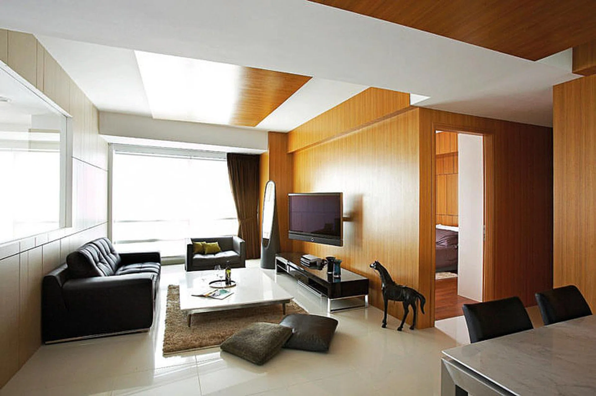 Cladding some walls in timber veneer tones down bright daylight that streams in from the floor-to-ceiling windows. Vases, glasses and tray, from The Touch. Green cushions and furry cushions, from Haier Living.