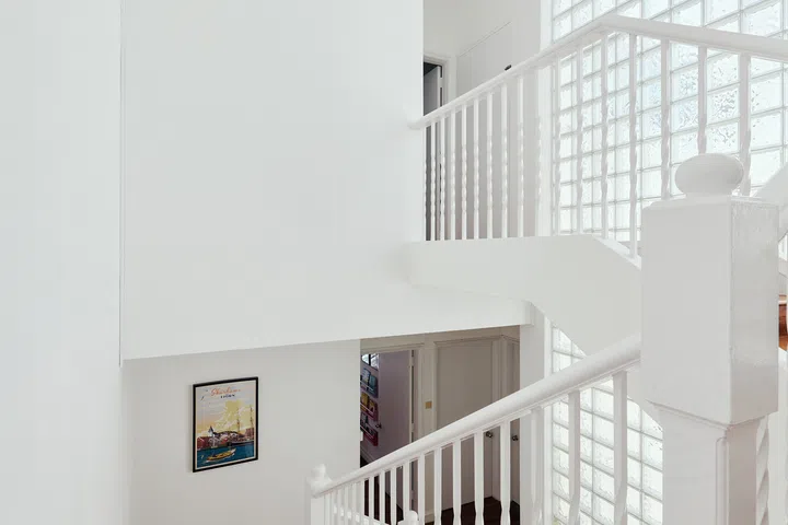 Original glass-brick walls draw natural light deep into the interior—a distinctive architectural feature found throughout the development.