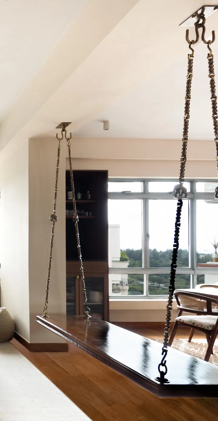 The traditional oonjal hangs from a beam in between the living room and dining area. 