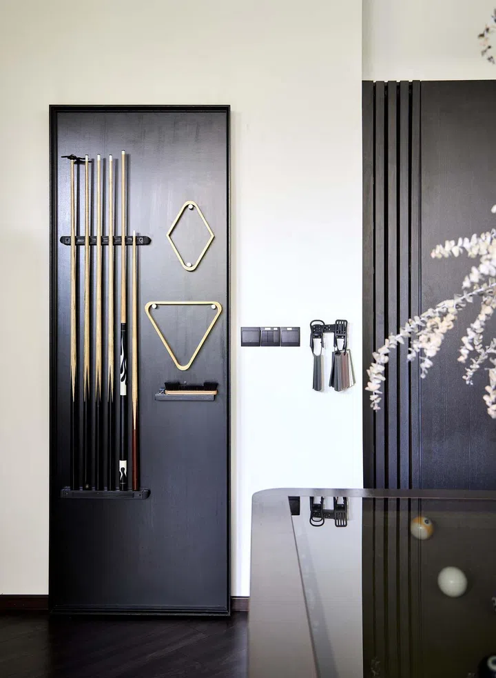 In interior designer Cheryl Gay of Coterie Design's 3,600 sq ft semi-detached home in Yio Chu Kang, the home office's powder room is concealed behind a cue hanger door.