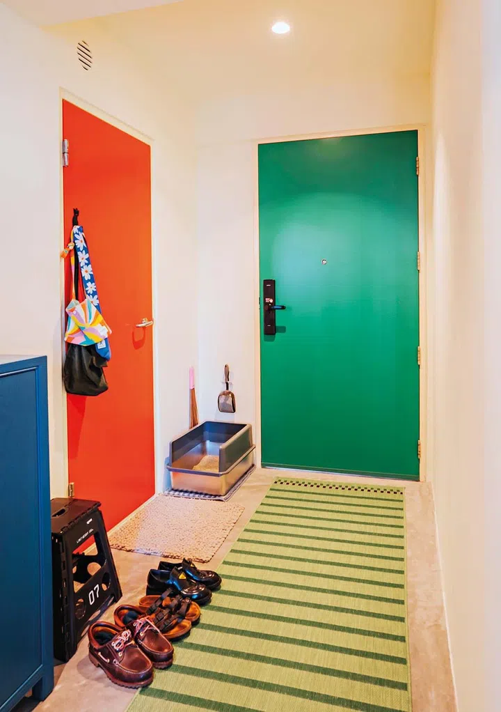 Colours abound in the foyer, from the brightly coloured doors to the blue sideboard and striped rug.