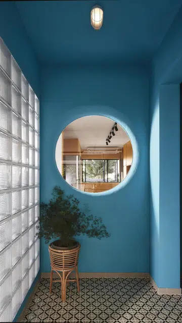 A porthole in the wall connects the various living areas in this 1,367 sq ft 5-room HDB at Bedok Reservoir Road. 