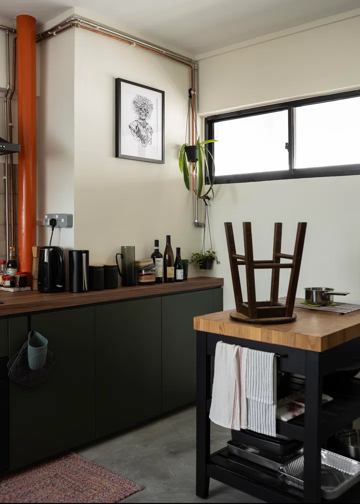 An existing bright orange pipe in the kitchen was retained.