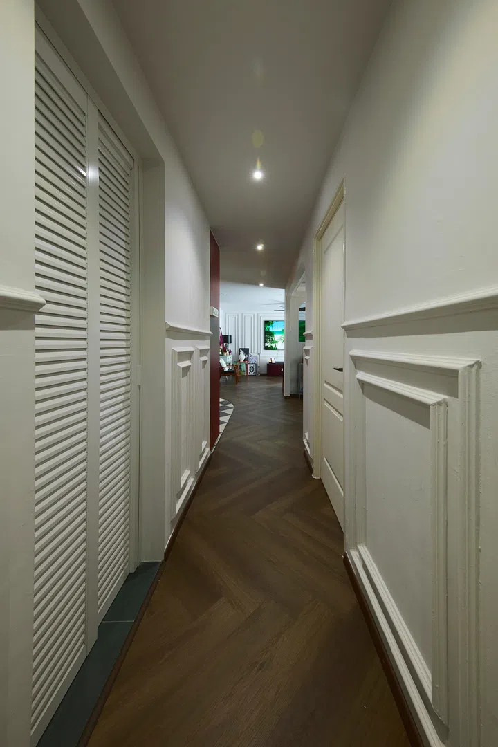 Beyond the studio, the corridor continues the home’s classical detailing, leading towards the more private areas of the house.