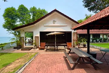 Panoramic views of the Ubin Straits frame the red-brick patio, inviting guests to gather around a repurposed BBQ pit, now a hand-built pizza oven. Features a private gate to Changi Point Coastal Walk.