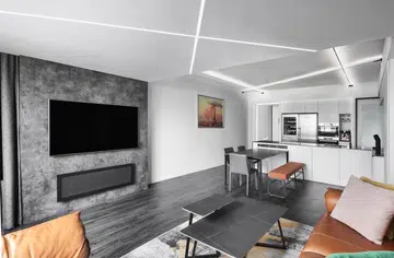 A reconfigured space defined by crisp monochrome finishes and bold LED ceiling strips—a design move Kelvin calls one of his favourite features.