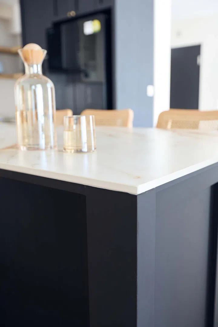 A set of glass and cork water decanter set on the kitchen island dining table of this Shaker-style 5-room HDB flat in Tampines Ave 8.