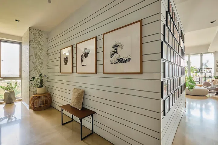 Three framed black-and-white prints and a solitary stool in the entrance foyer.
