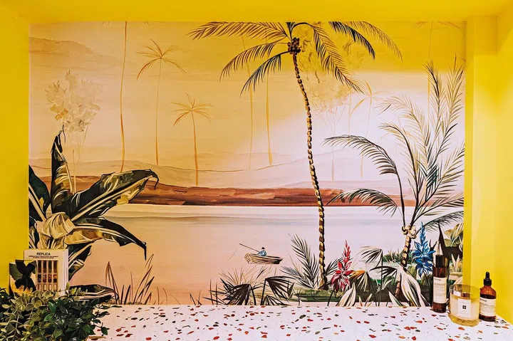 A mural wallpaper, “Kingfisher” by Flor Chedufau, pulls the tropical concept together.