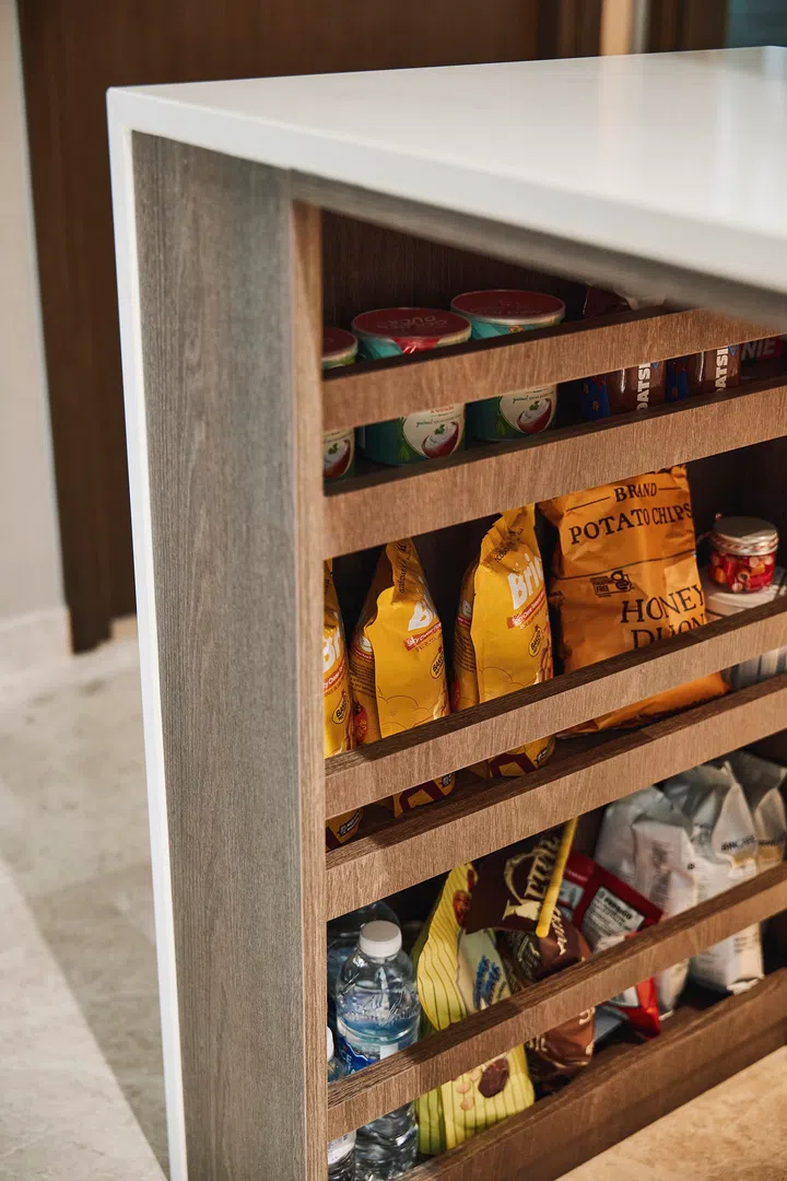 Hotel-inspired pull-out trays below the island store snacks and essentials, just like a private minibar.