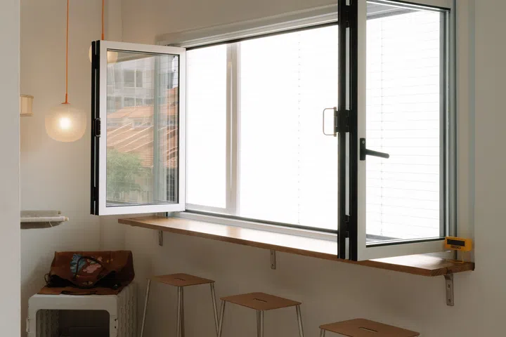Rather than settling for standard windows, the couple worked with their designer to commission an inward-opening version, allowing the apartment to be safely cat-proofed without compromising ventilation or natural light.