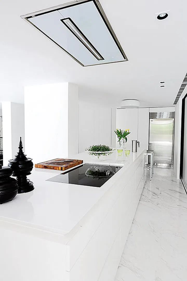 A 5-room New York-style loft home. In the kitchen, sliding polyurethane-clad doors hide appliances. A recessed cooker hood in the ceiling removes cooking fumes in the open-concept area.