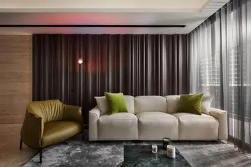 Soft textures and warm timber tones define the living area, accented with subtle greens that add depth without disrupting the room’s quiet elegance.