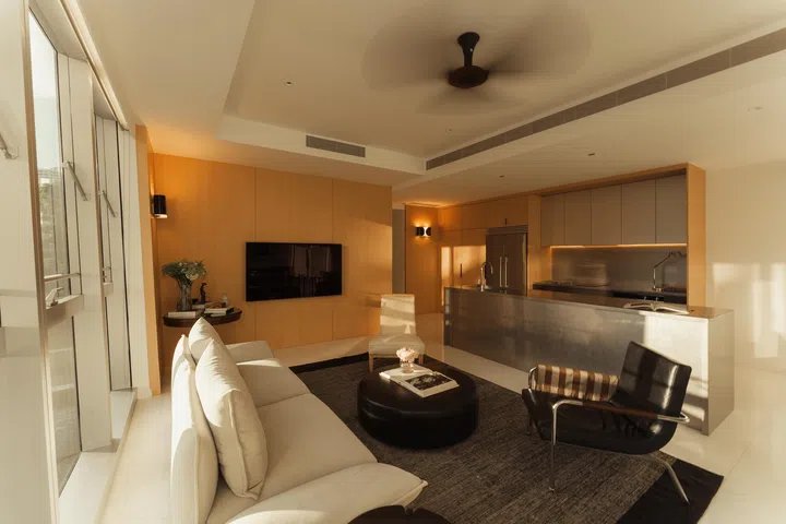 The open-plan layout highlights the home’s sense of flow, with the steel island anchoring the space between living and kitchen zones.