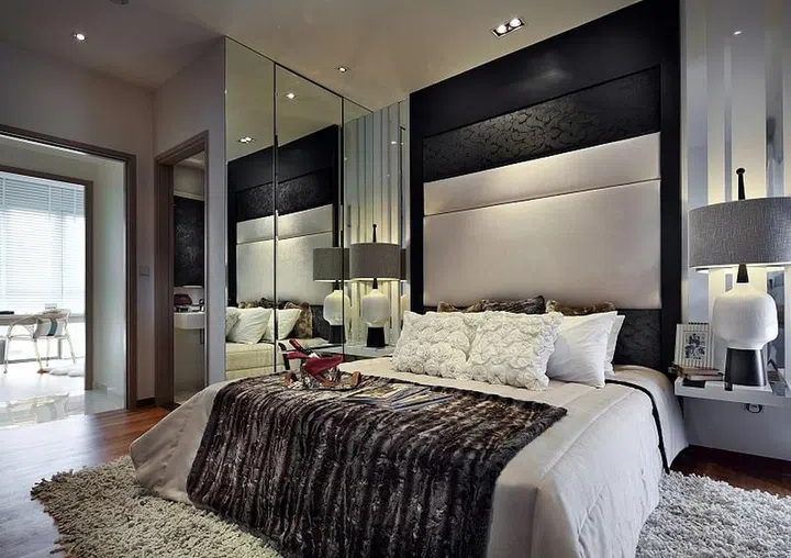 In this master bedroom of a condominium unit in the Eight Courtyards condo, beddings like bed throws, fur and silk cushions, lush duvet sets lend a grand, hotel-like look.