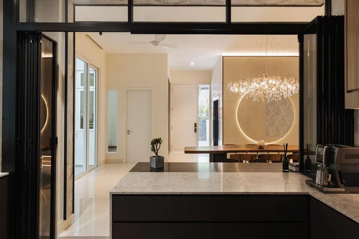 View of the dining room from the dry kitchen in this 6,534 sq ft semi-detached at Jalan Belibas, Upper Thomson designed by Metre Architects.