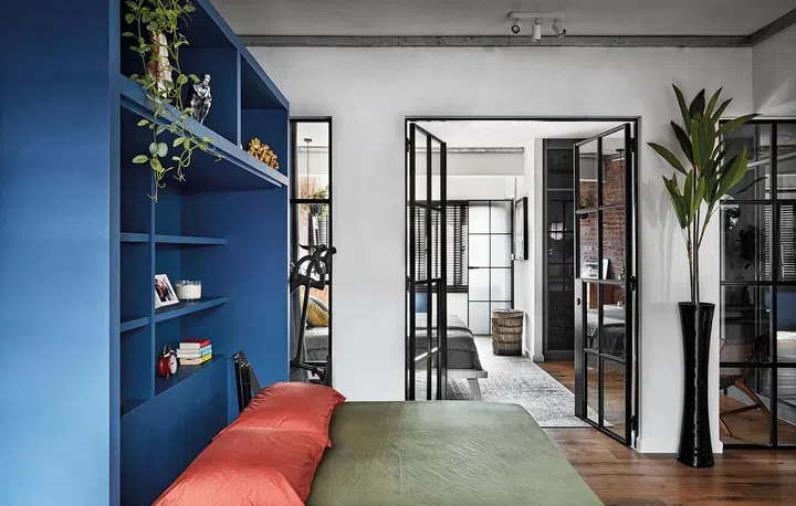 All decked out in blue, the customised unit in the study area holds shelves and hides a guest bed.