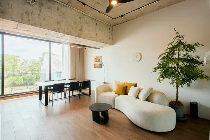 On the fourth floor, a secondary living area is designed as a more relaxed, informal space, with full-height windows opening out to greenery..