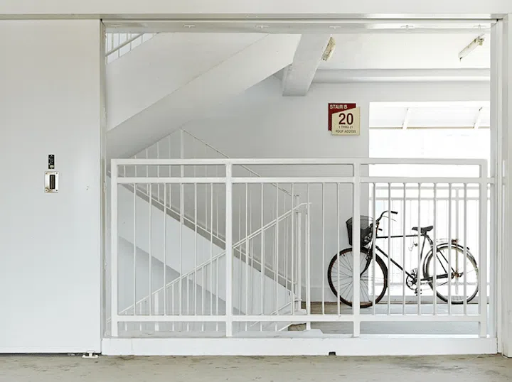 Bicycle parked by the stairwell in an older HDB building.