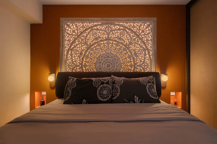 The softly illuminated hand-carved Balinese panel creates a dramatic focal point, bringing warmth, craftsmanship and a touch of Bali into the couple’s private retreat.