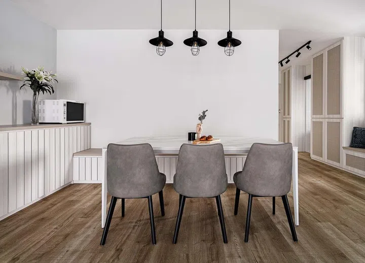 White dining table with 3 pendant lamps hanging over