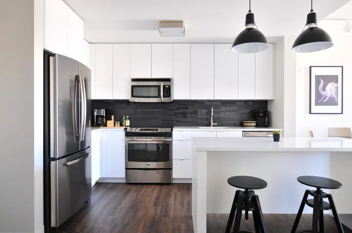 Black, dark wood, and all-white kitchen cabinets.