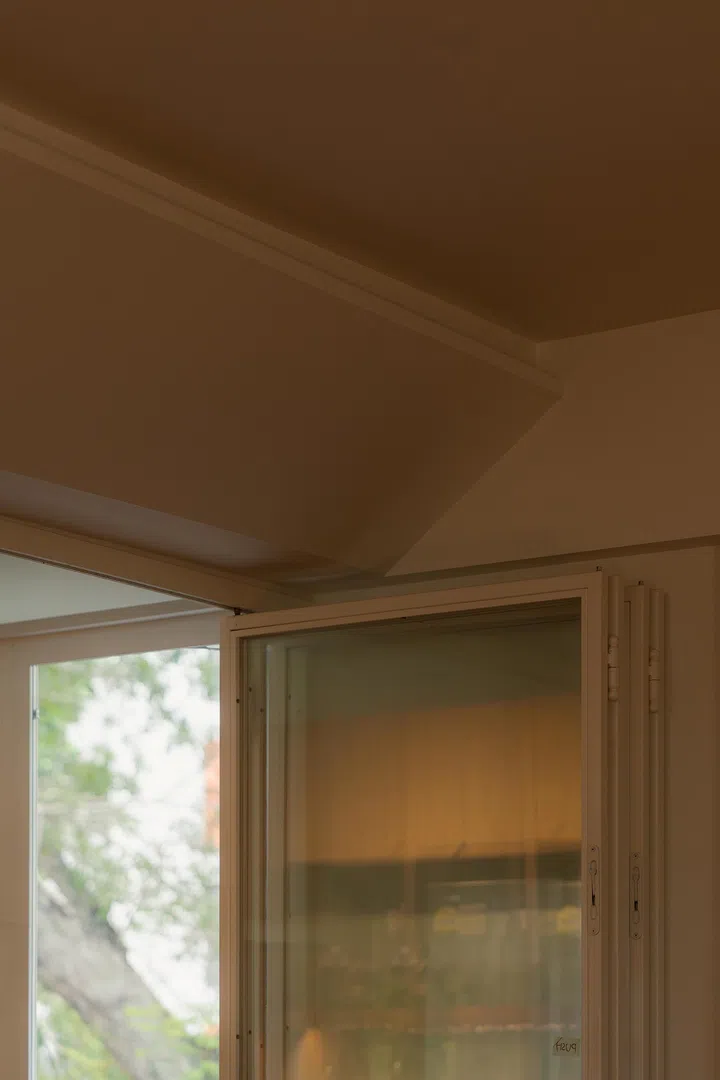 A chamfered bulkhead turns an awkward corner into a sculptural gesture while concealing air-conditioning conduits.