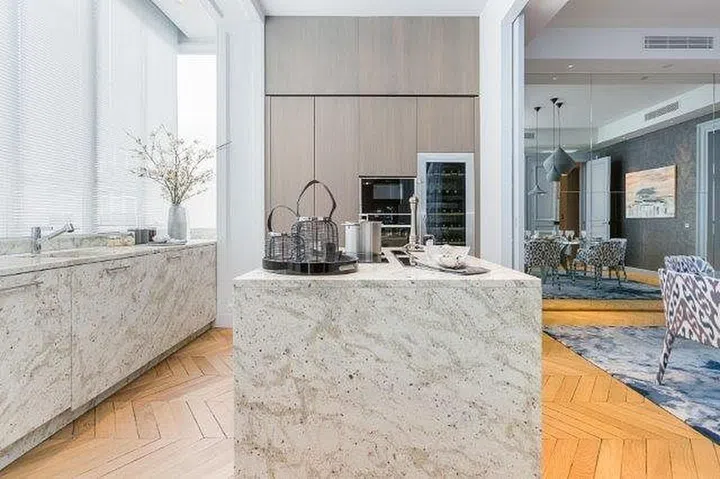 The smooth, polished surface of the counters reflects a gentle luminosity, amplifying the ethereal ambiance within the kitchen space.