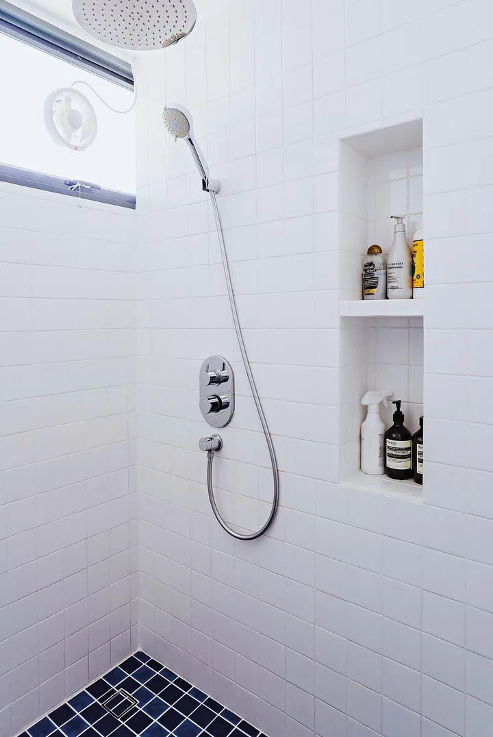 The shower- only bathroom in the master bedroom takes on the colours of a pool. Niches were built into the space for a clean and streamlined design.