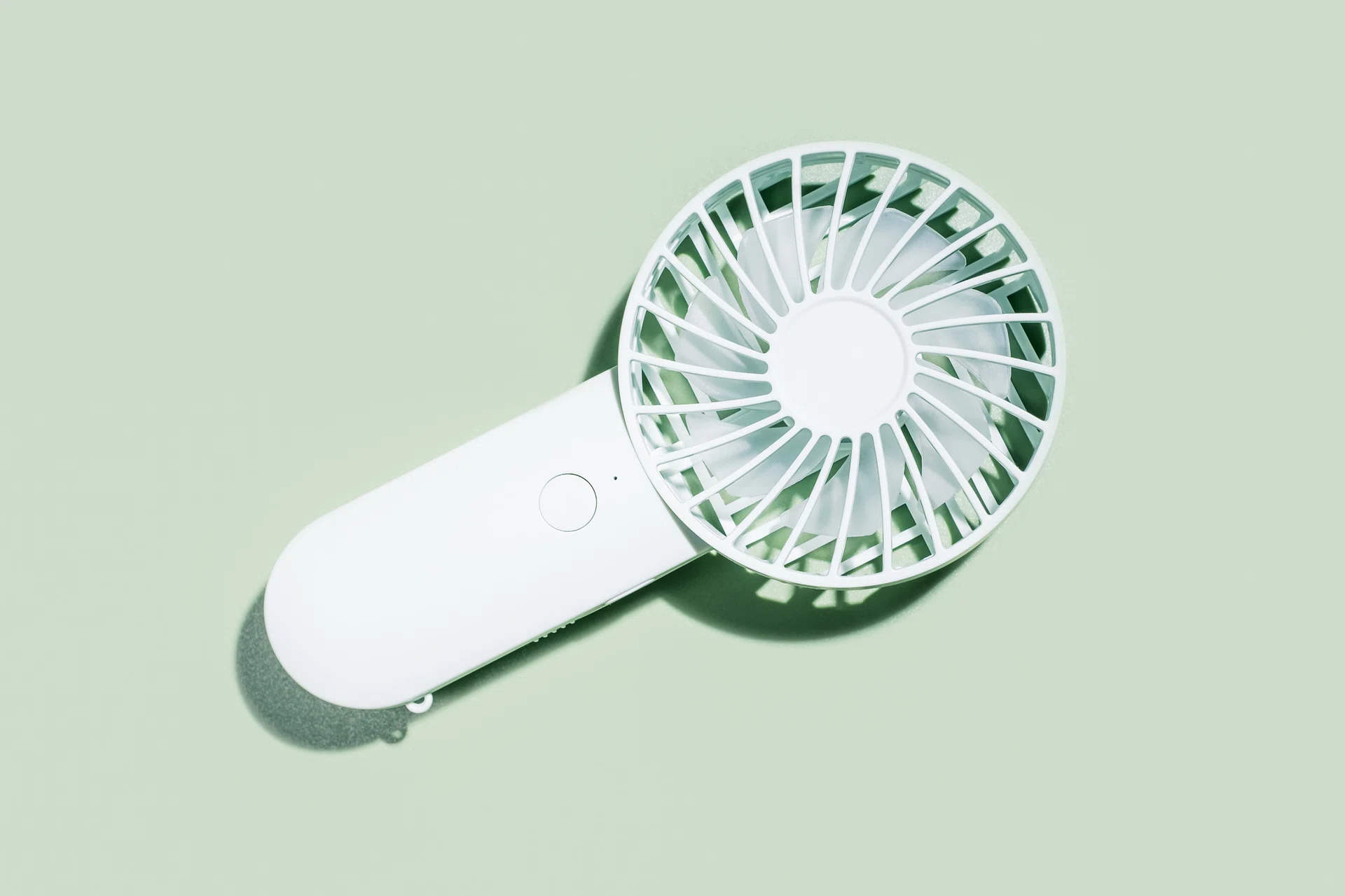 Small fan on green background close-up, top view.