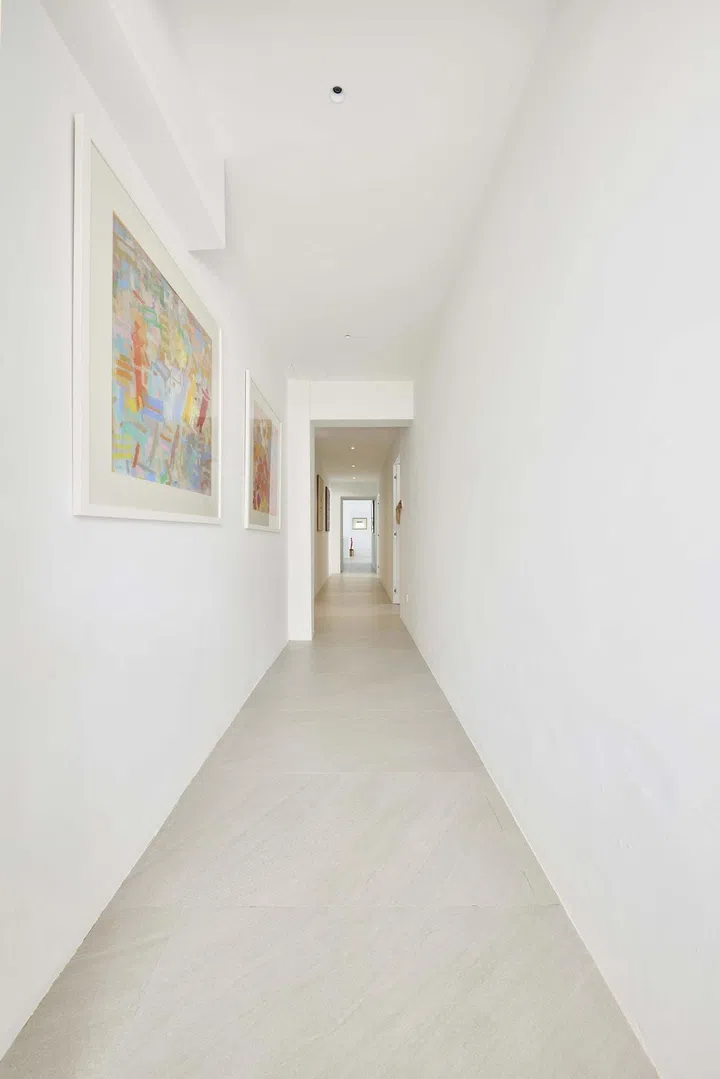 Artwork line the clean, minimal, white walls of this 3,500 sq ft 4-bedroom Pandan Valley condo.