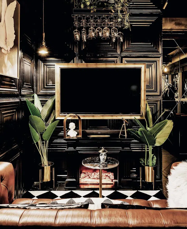 The TV set is conceived as a piece of art. The gilded frame creates the impression of moving  artwork. A faux fireplace below adds cosiness sans the actual heat.