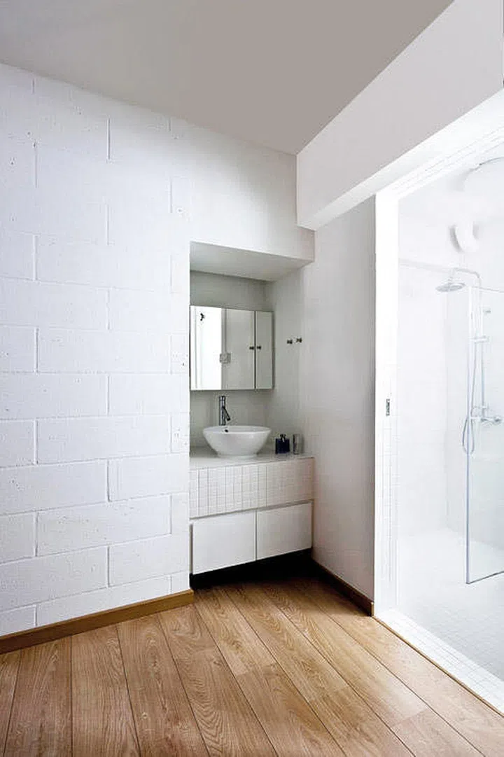All white sink outside a white bathroom. Interior Design by Box.ID Studio