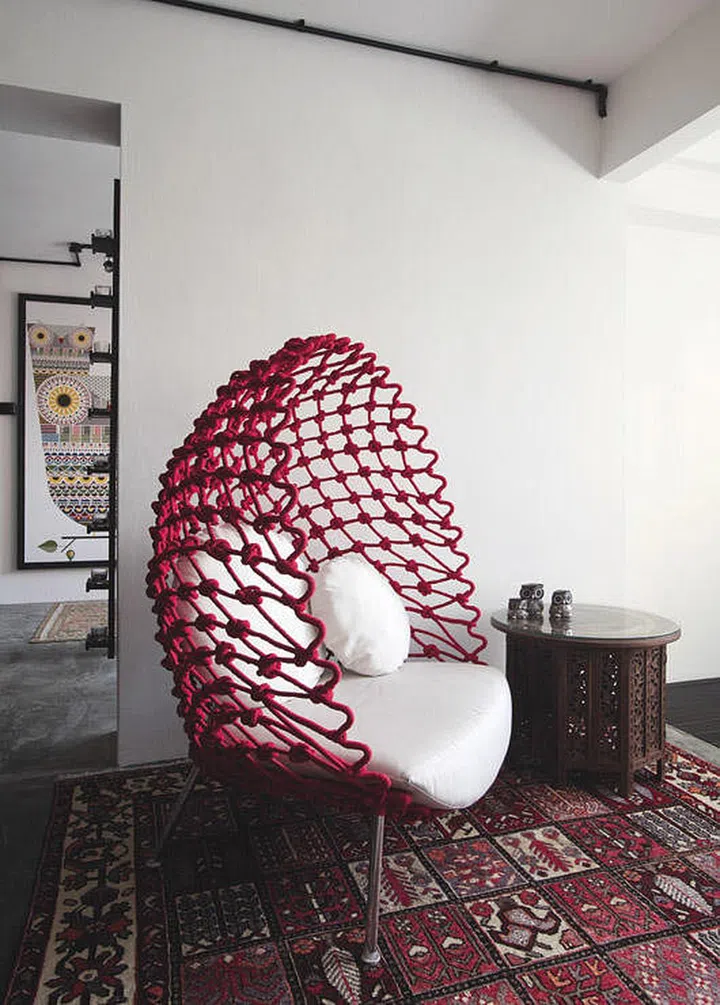 Plenty of soft furnishings like rugs, upholstered furniture, colourful paints and wood furniture fill the home, giving it a cosy atmosphere and softening the gritty look of the concrete floor.