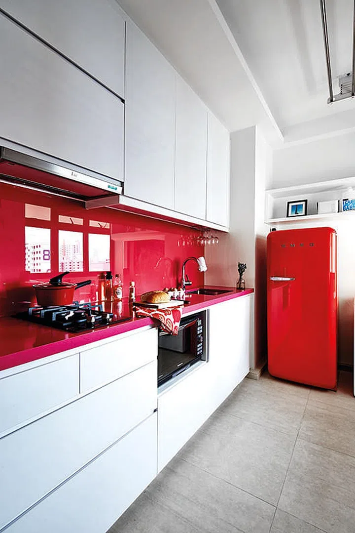 The geomancer recommended using red in the kitchen, so Carole chose a red Smeg fridge, which she matched with an unusual magenta quartz kitchen countertop by Silestone. 