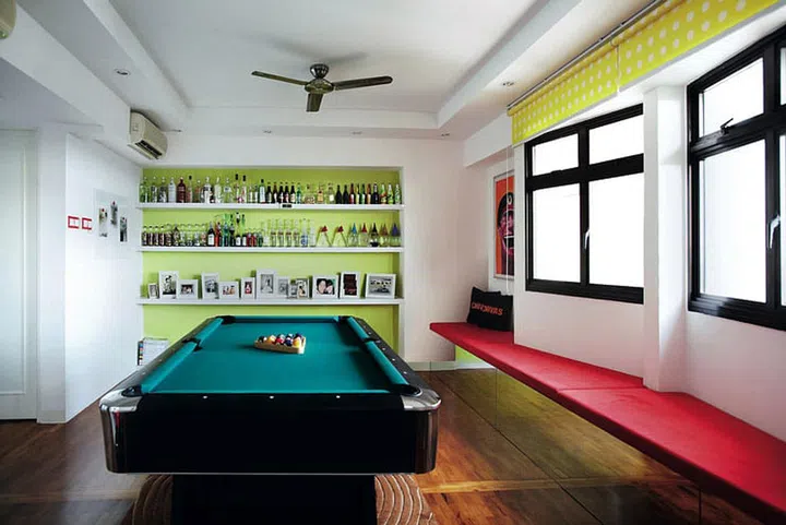 In keeping with the colour blocking trend, bold blocks of lime green, red and yellow contrast with the green felt of the pool table.