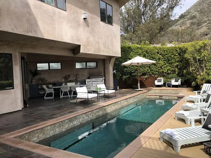 The swimming pool, al fresco dining table, and a row of sun deck chairs in Eva Longoria's 8,603sqf 3-storey mansion in the Hollywood Dell district, which she purchased in 2006 for the sum of USD$3.6 million.