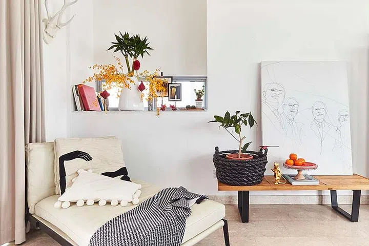 Interior stylist Mike's white living room. He added a bouquet of festive flowers, along with little trinkets to a wooden bench console to liven up the room.