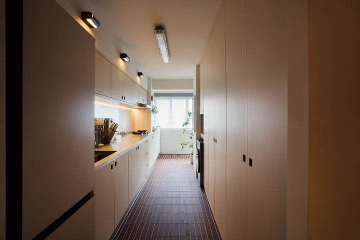 The terracotta shade of the foyer and kitchen flooring reappears in the cabinet handle inserts.